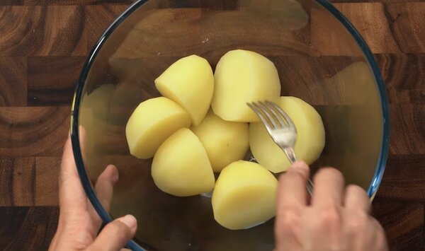 Dùng nĩa dằm khoai tây đã luộc chín